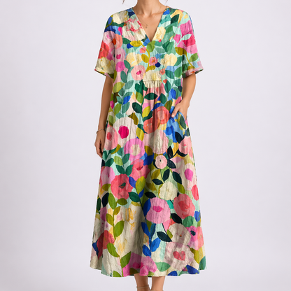 Floral - Woman wearing a woven floral V-neck maxi dress with short sleeves and side pockets.