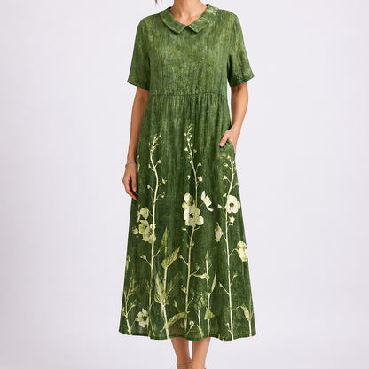 Green - Woman wearing a woven floral V-neck maxi dress with short sleeves and side pockets.