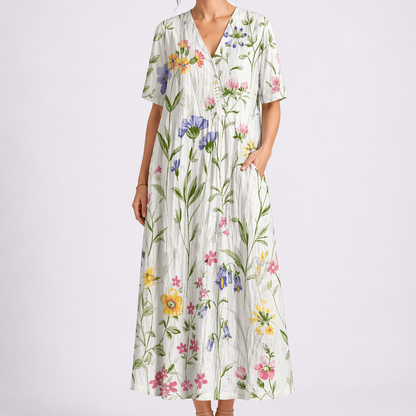 White - Woman wearing a woven floral V-neck maxi dress with short sleeves and side pockets.