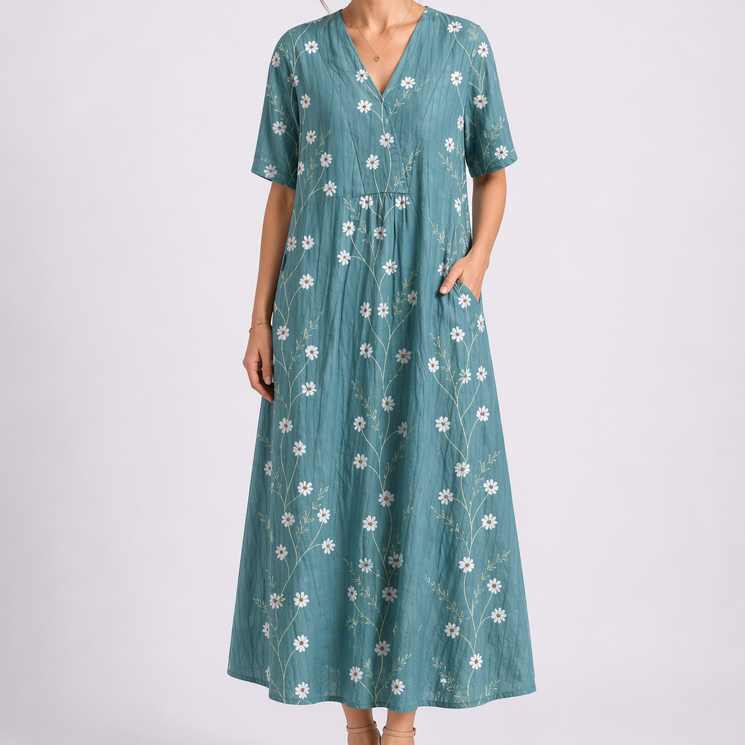 Turquoise - Woman wearing a woven floral V-neck maxi dress with short sleeves and side pockets.
