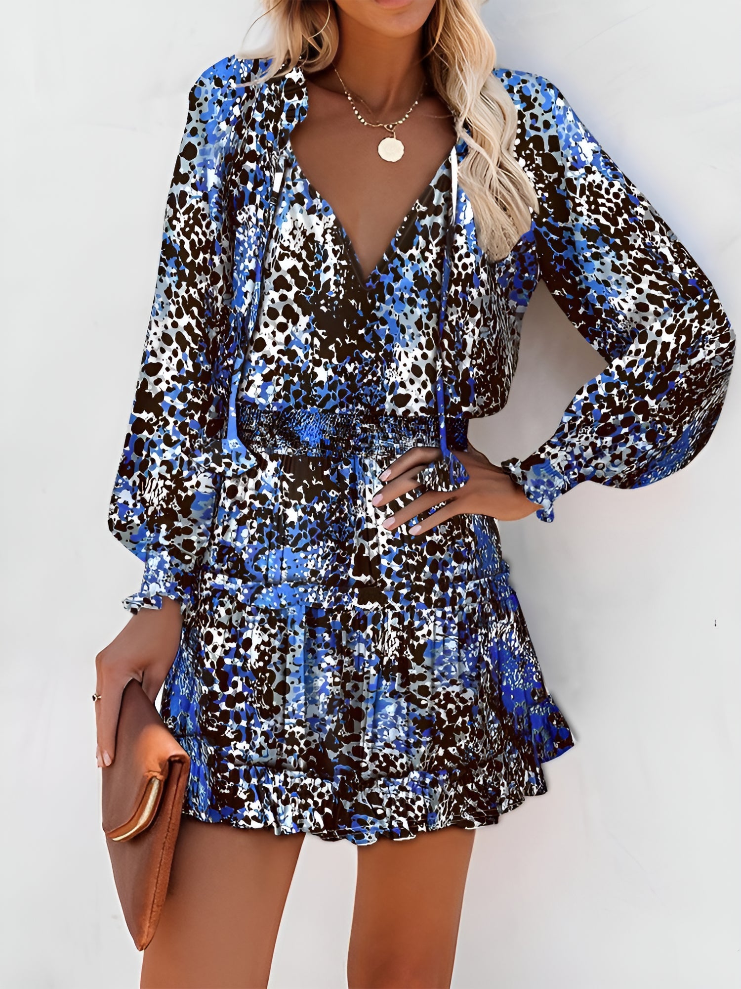 Blue - Woman wearing a woven floral V-neck mini dress with long sleeves, smocked waist, and tiered ruffle skirt.