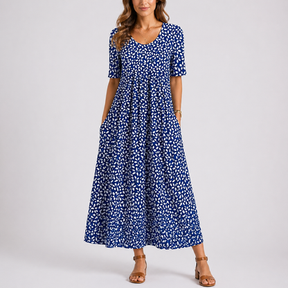 Blue - Woman wearing a woven leaf-print short-sleeve smock maxi dress with a scoop neckline and flowing skirt.