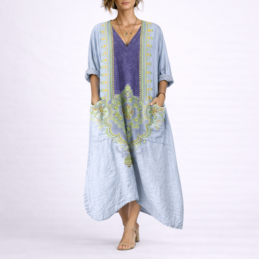 Blue & Purple - Model wearing a woven paisley print relaxed midaxi dress with a v-neckline, rolled sleeves, large front buttons, and patch pockets.