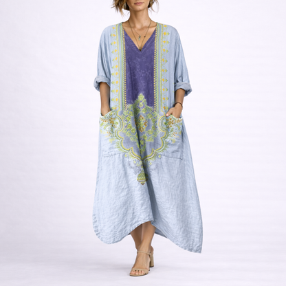 Blue & Purple - Model wearing a woven paisley print relaxed midaxi dress with a v-neckline, rolled sleeves, large front buttons, and patch pockets.
