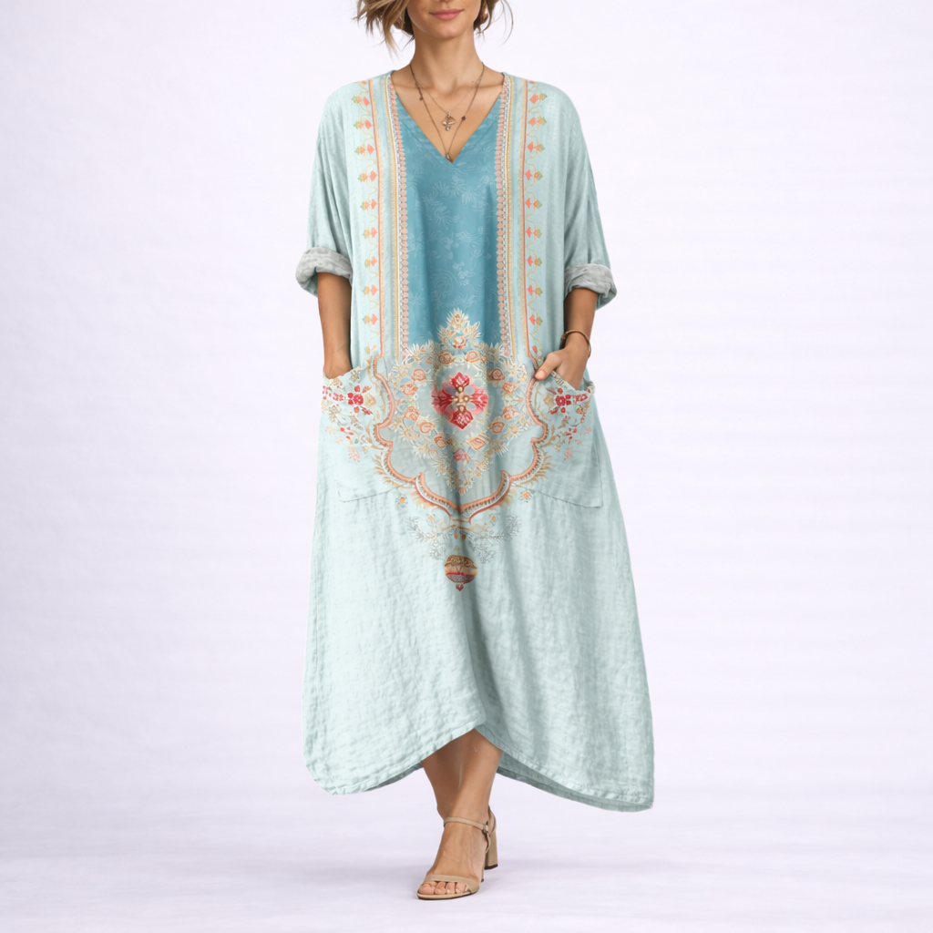 Green & Blue - Model wearing a woven paisley print relaxed midaxi dress with a v-neckline, rolled sleeves, large front buttons, and patch pockets.