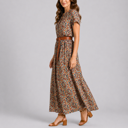 Floral - A woman wearing a woven paisley short-sleeve maxi dress with a V-neckline and functional side pockets, styled with a leather belt.