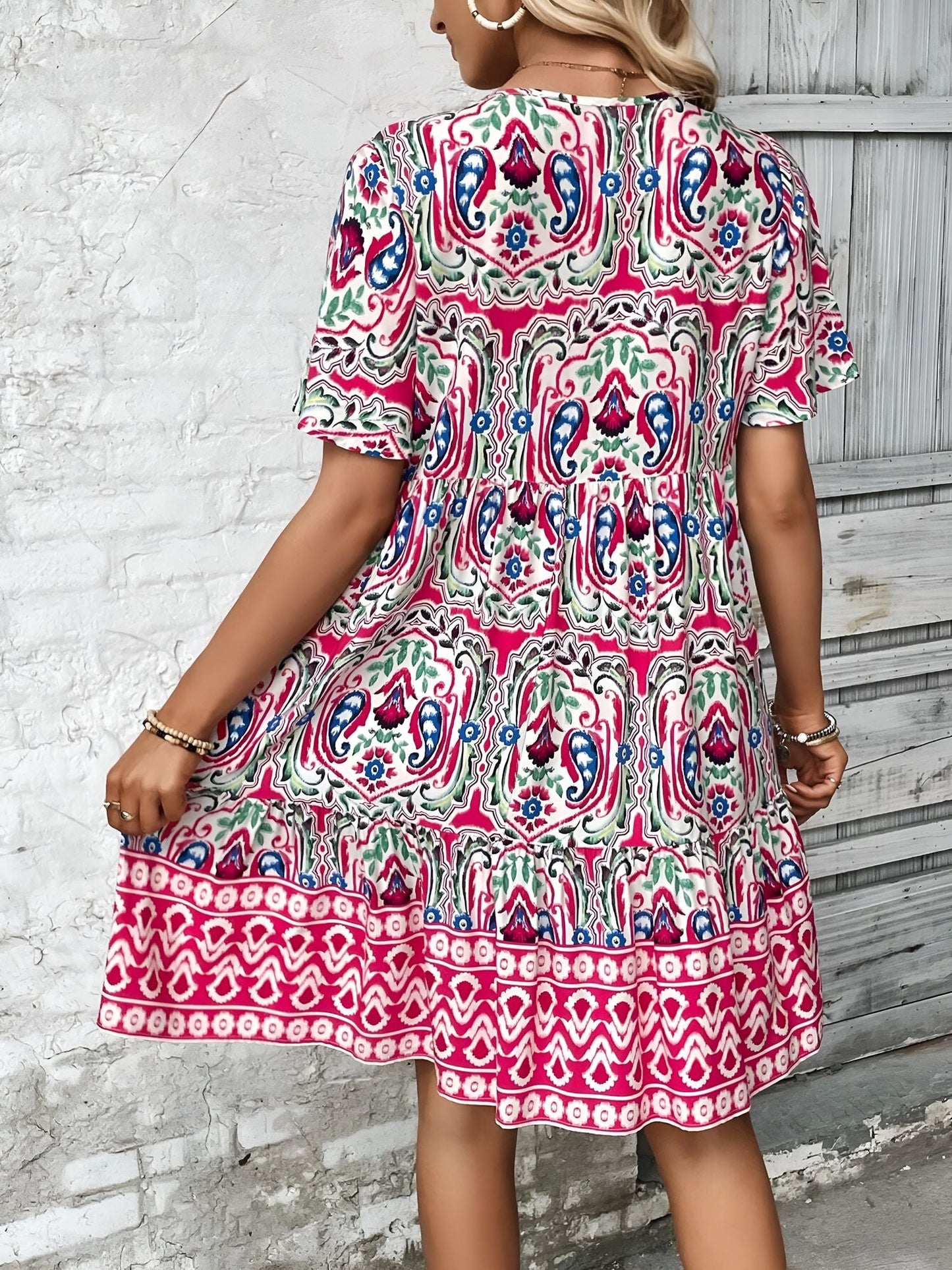 Rose Red - Woman wearing a woven paisley print V-neck tiered mini dress with short sleeves and front button detailing.