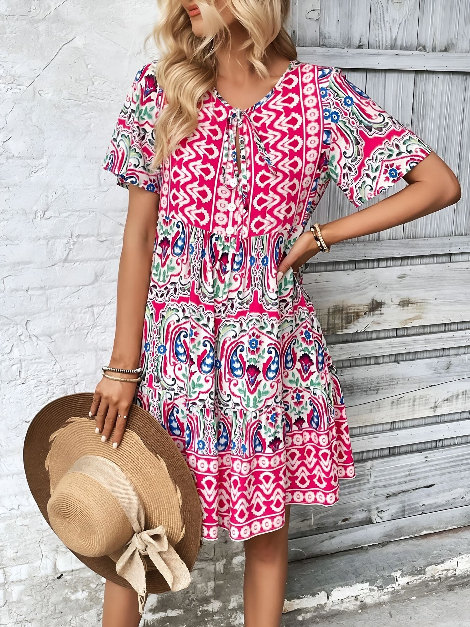 Rose Red - Woman wearing a woven paisley print V-neck tiered mini dress with short sleeves and front button detailing.