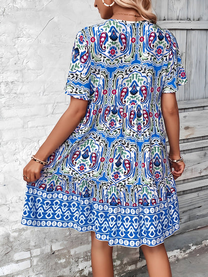 Blue - Woman wearing a woven paisley print V-neck tiered mini dress with short sleeves and front button detailing.