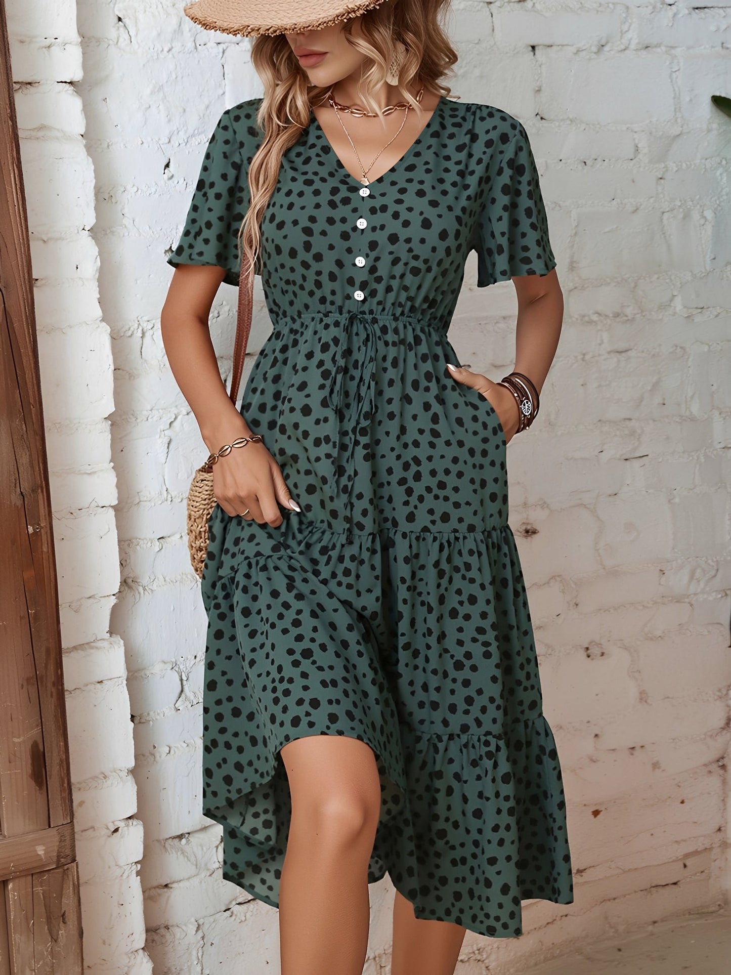 Dark Green - Woman wearing a spot pattern V-neck tiered midi dress with short sleeves and side pockets, standing in an architectural hallway.