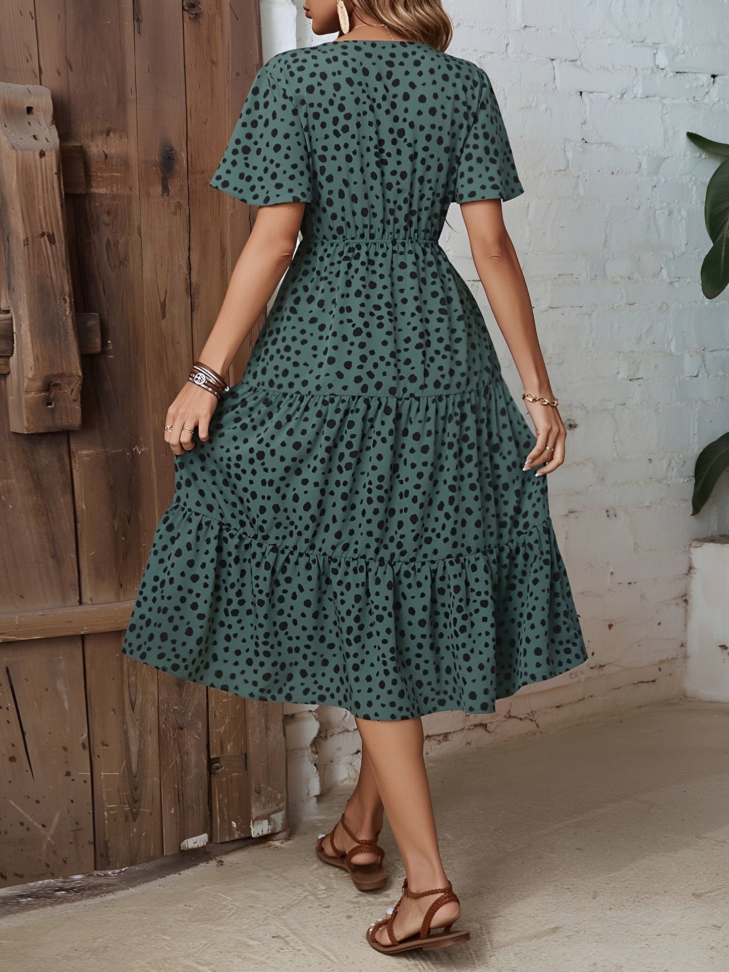 Dark Green - Woman wearing a spot pattern V-neck tiered midi dress with short sleeves and side pockets, standing in an architectural hallway.
