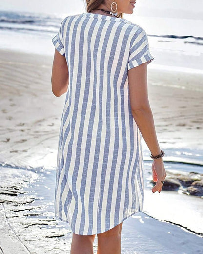 Light Blue - Model on a beach wearing a woven striped short-sleeve shirt dress with a button-front design and relaxed fit