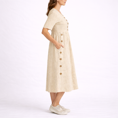 Beige - Woman wearing a striped short-sleeve midi dress with asymmetric wooden button detailing and side pockets, standing against a white background.