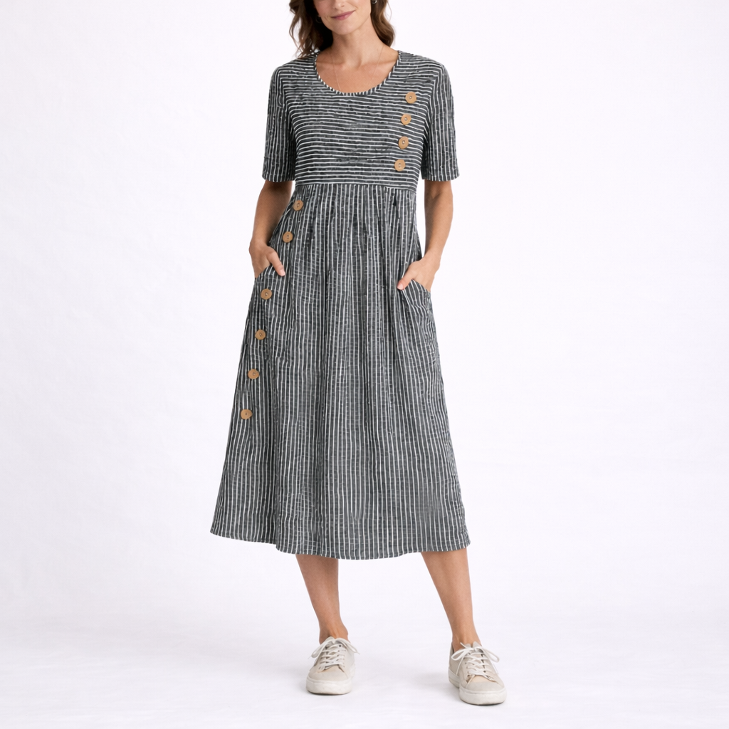 Gray - Woman wearing a striped short-sleeve midi dress with asymmetric wooden button detailing and side pockets, standing against a white background.